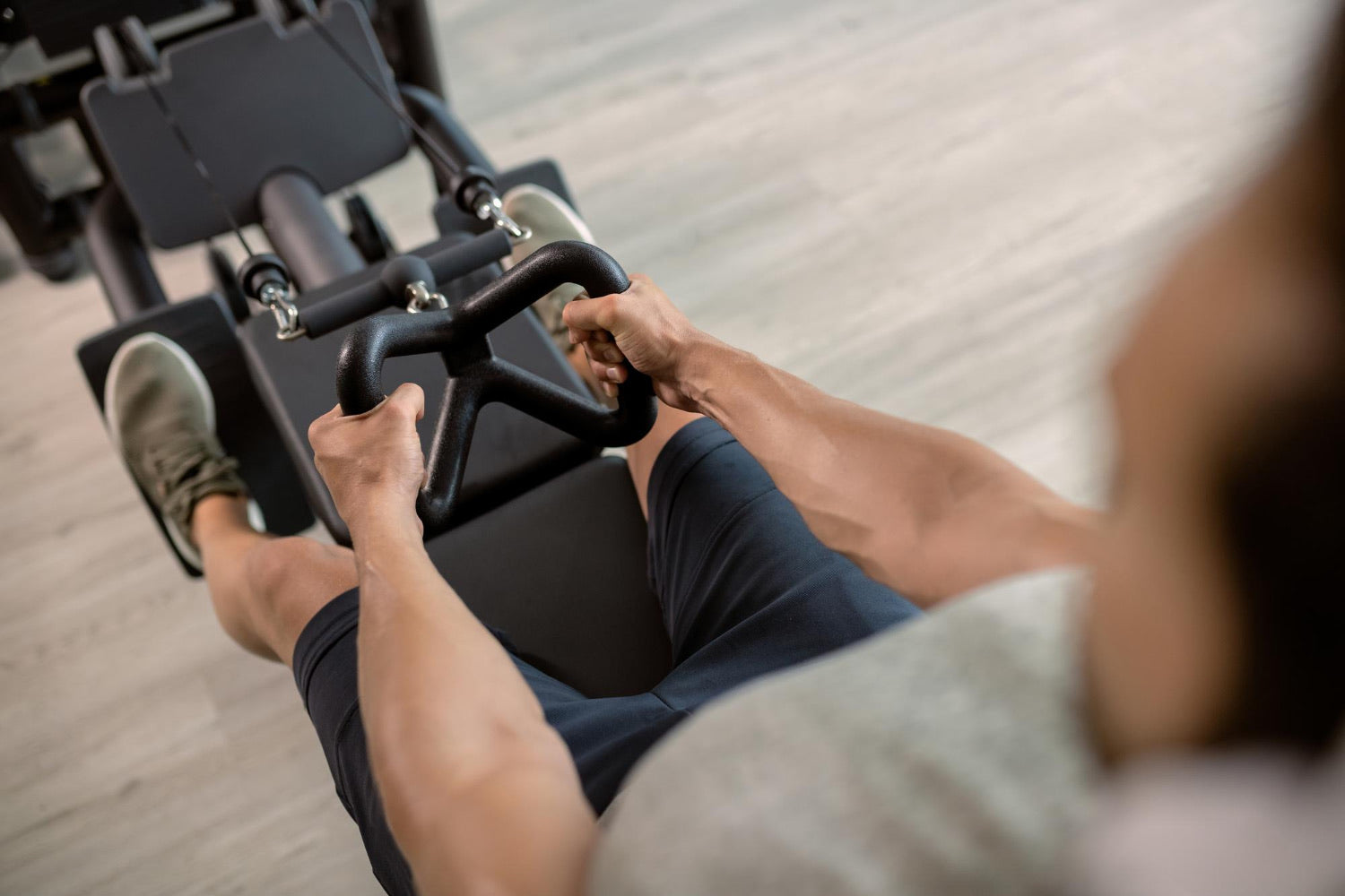 Man på gymmet som kör dropset på roddövning