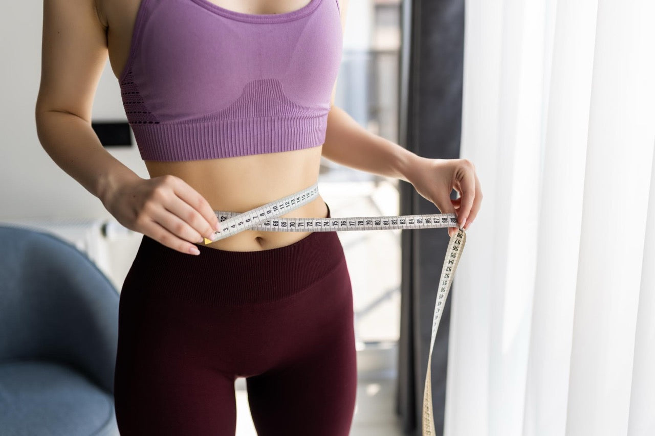 Woman showing her weightloss with measuring band